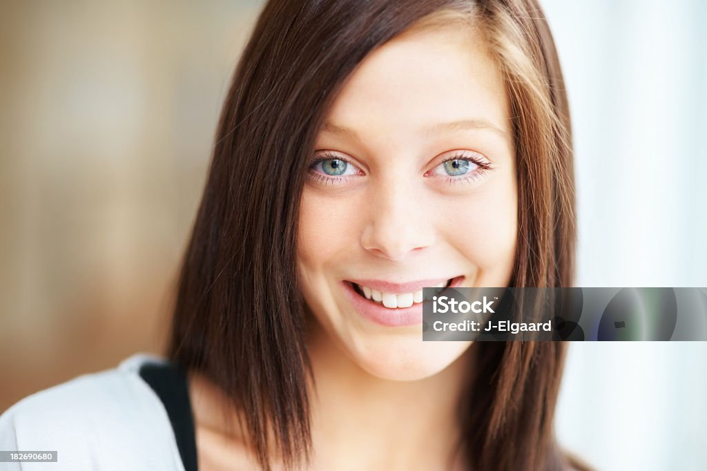 Closeup of a happy teenage female Closeup portrait of a cute blue eyed girl smiling against a bright background 16-17 Years Stock Photo