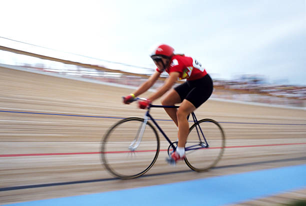 a female bike racer flies around a turn in a racing velodrome