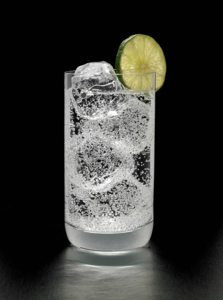 Gin and Tonic Cocktail on black background A refreshing gin, vodka or rum and tonic cocktail with a lime garnish, shot against a black background. gin tonic stock pictures, royalty-free photos & images