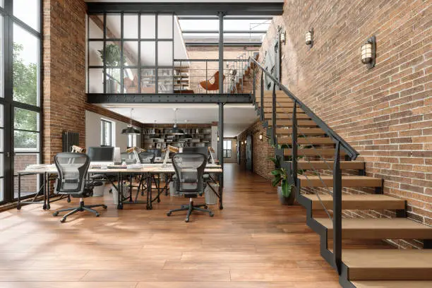 Photo of Modern Loft Office Interior With Desks, Computers, Office Chairs, Brick Wall And Upstairs Waiting Room