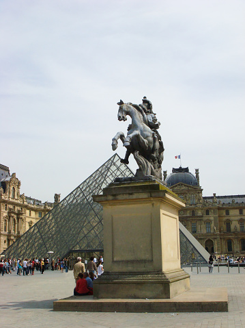 View of statue Louis, Louvre and pyramid on a summer day. Paris. France.