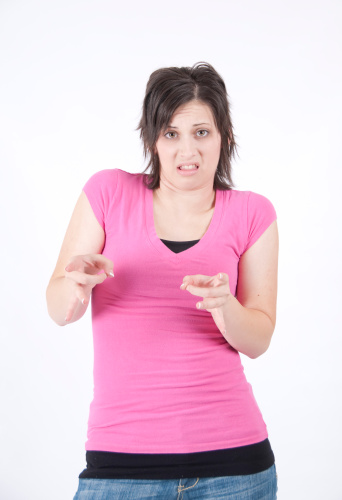 Young woman with a pink shirt signing HATE in american sign language