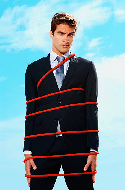 istock Young business executive tied up with a rope 182694670