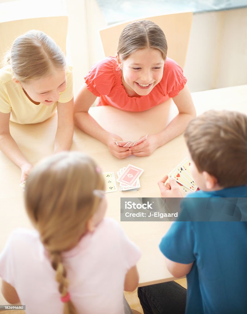 Linda poco niños jugando un juego de cartas juntos - Foto de stock de 10-11 años libre de derechos