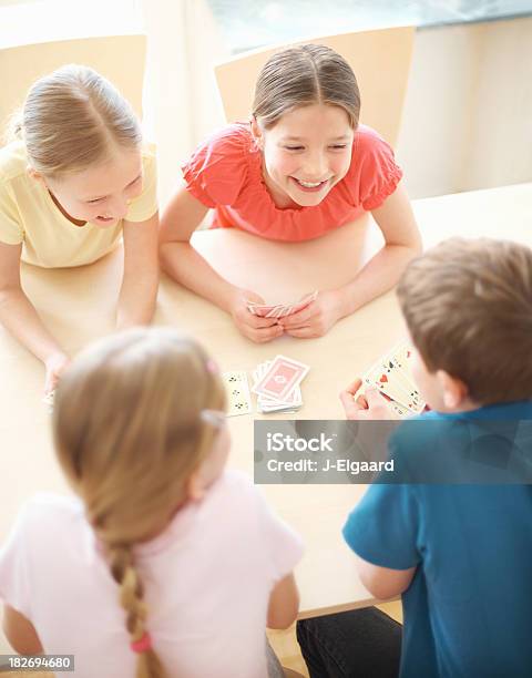 Linda Poco Niños Jugando Un Juego De Cartas Juntos Foto de stock y más banco de imágenes de 10-11 años - 10-11 años, 8-9 años, Actividades recreativas