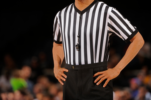 A referee waits for the time out to end during a basketball game.
