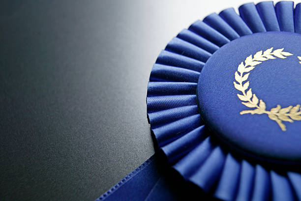 blue ribbon premios en gris oscuro fondo graduado - ribbon award perfection winning fotografías e imágenes de stock