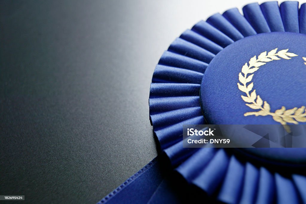 Blue ribbon rosette на темно-сером фоне разного размера - Стоковые фото Награда роялти-фри