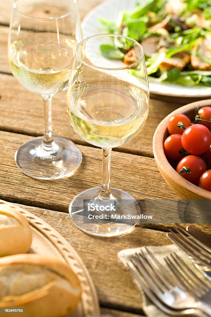 Alfresco dining with white wine Two glasses of chilled wine on a picnic table. Alcohol - Drink Stock Photo