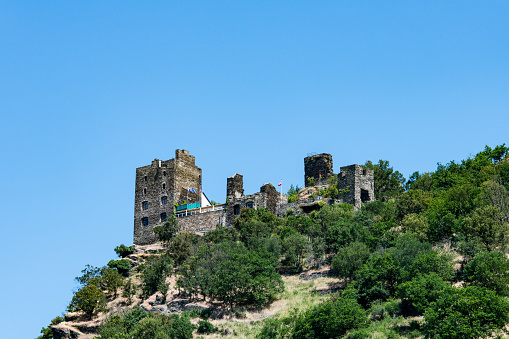 View from the river Rhine at the ruins of the Liebenstein castle on the top of a hill near the village of Kamp-Bornhofen.