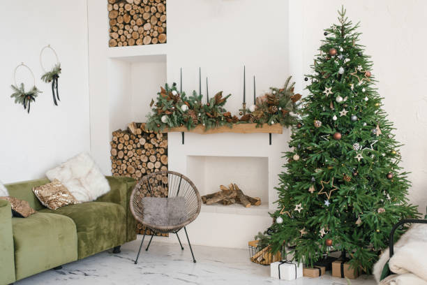 interior de casa rústica del salón con corona de navidad, chimenea, leña, sofá y árbol de navidad. adornos para la celebración de las fiestas navideñas - home decorating living room luxury fireplace fotografías e imágenes de stock