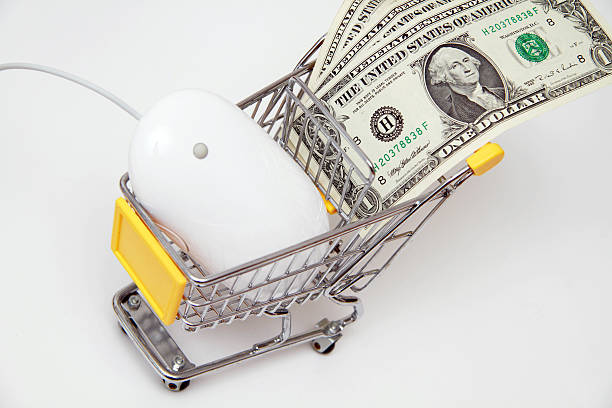 White mouse with banknotes in a shopping cart stock photo