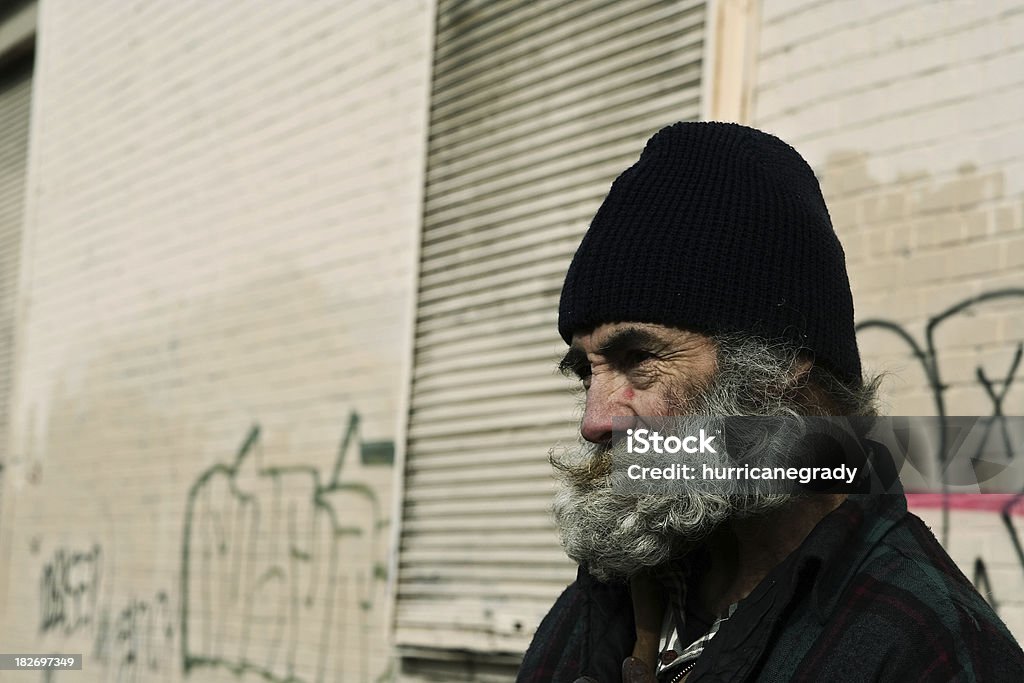 homeless man man against wall Adult Stock Photo