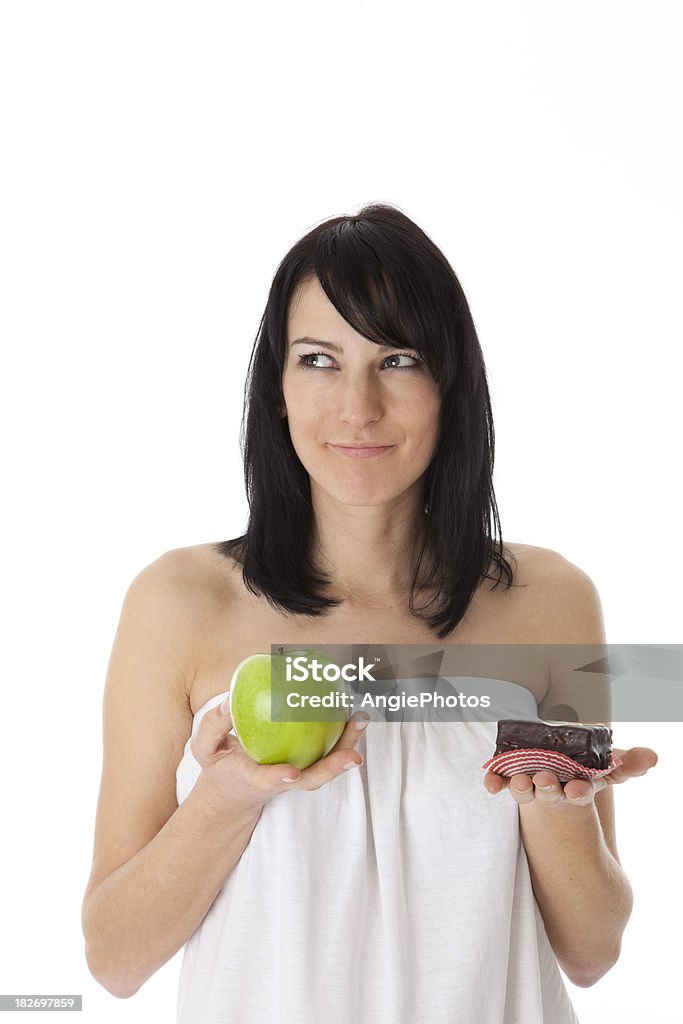 Joven mujer sosteniendo green apple y dulce pastel de chocolate - Foto de stock de 20-24 años libre de derechos