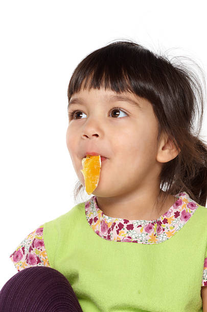 belle fille mangeant une orange - rappud2008 photos et images de collection