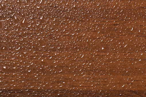 Top view of water drops on wooden background