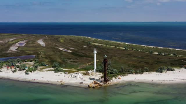 Aerial high view of new white and old lighthouses at sandy beach of Black sea on Dzharylhach island, Ukraine, Kherson region, Skadovsk. National park Dzharylgach. The biggest island of Black sea.