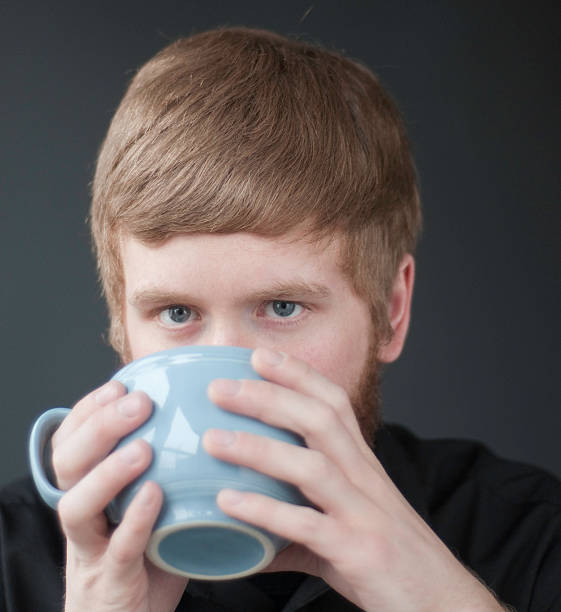 Der junge Mann trinkt aus cup. – Foto