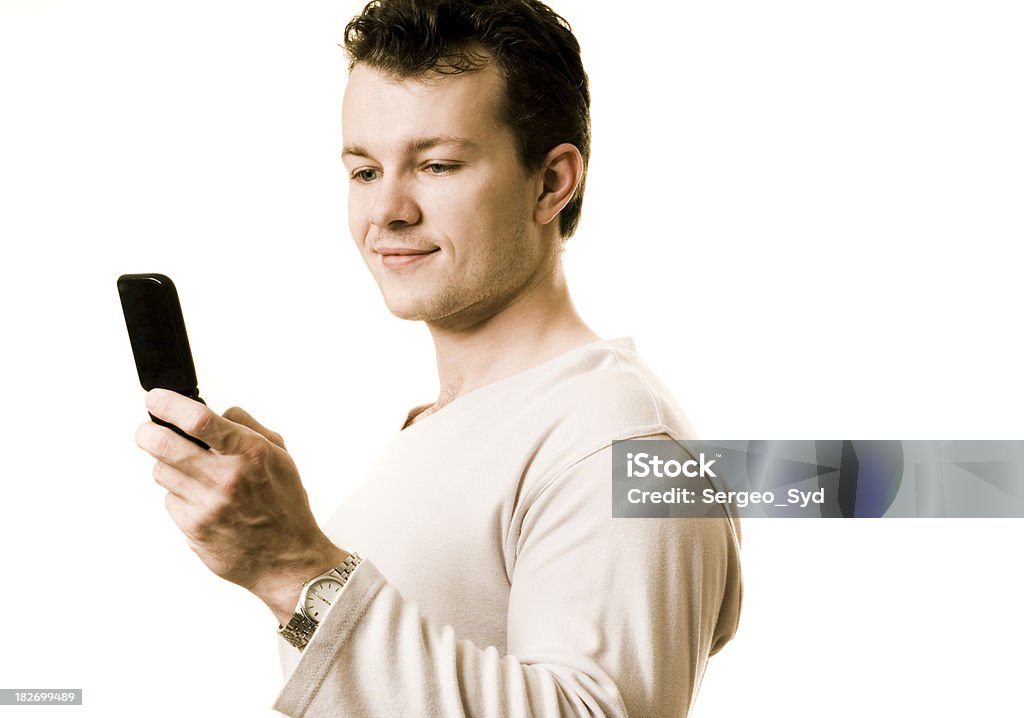 Un giovane Maschio adulto con il cellulare - Foto stock royalty-free di Abbigliamento casual