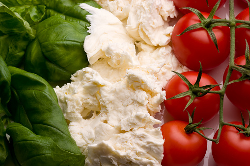 the ingredients of the famous dish tricolore salad aligned in the pattern of the Italian flag, the flag from which the salad takes its name.