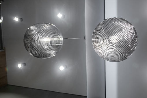 Modern light fixture in a form of different size balls hanging from the ceiling