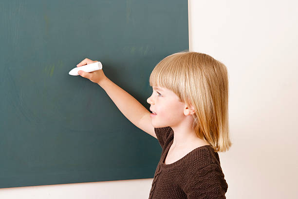 istock Young girl with chalk at the blackboard 182700182