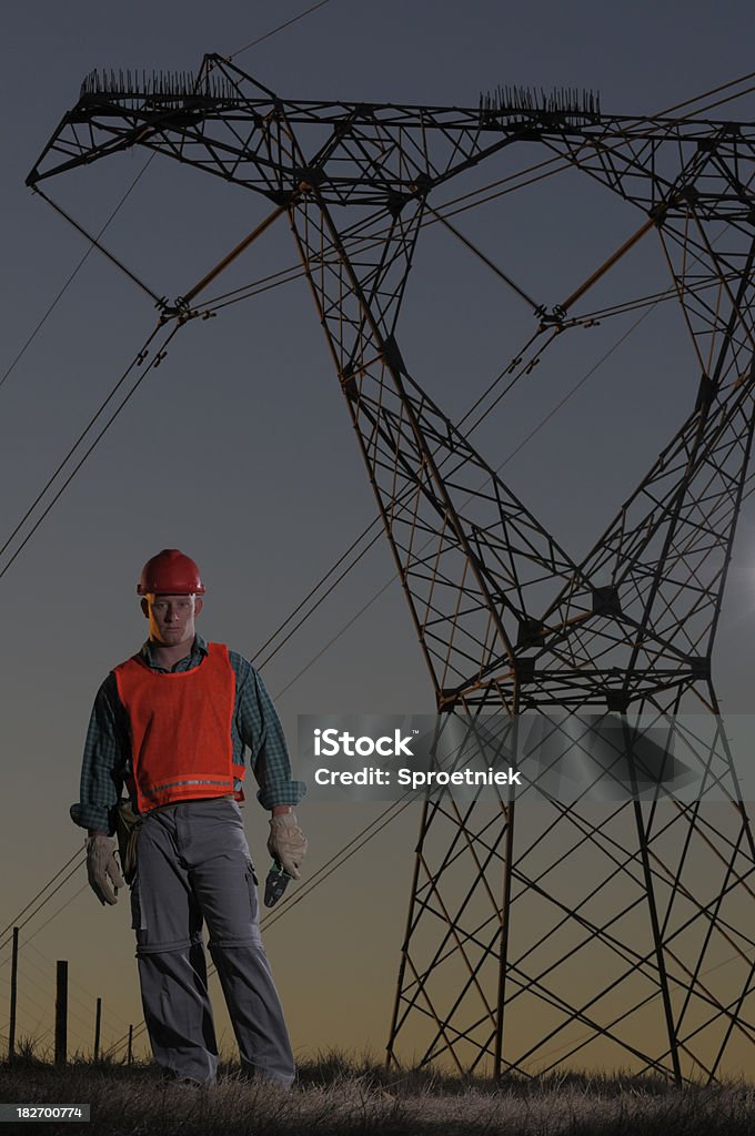 Utility работник против power pylons Широкий - Стоковые фото Вертикальный роялти-фри