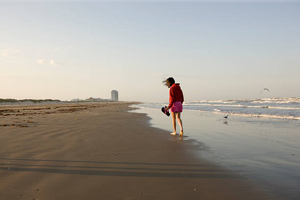 istock Girl walking on the beach 182701030