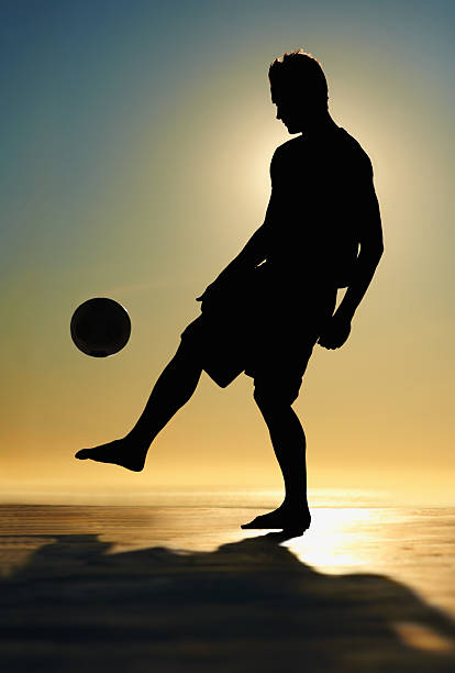 istock Silhouette image of a man practicing soccer ball at sunset 182701083