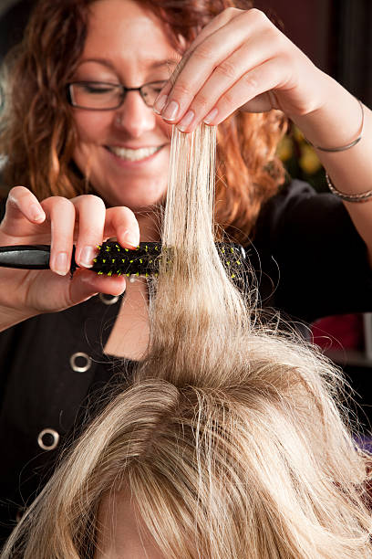 Hairstylist teasing hair stock photo