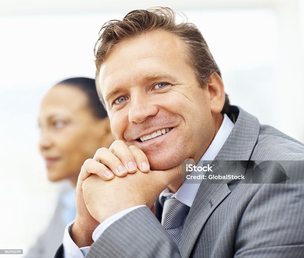 Sorridente maturo Uomo d'affari con il collega in background - Foto stock royalty-free di 40-44 anni