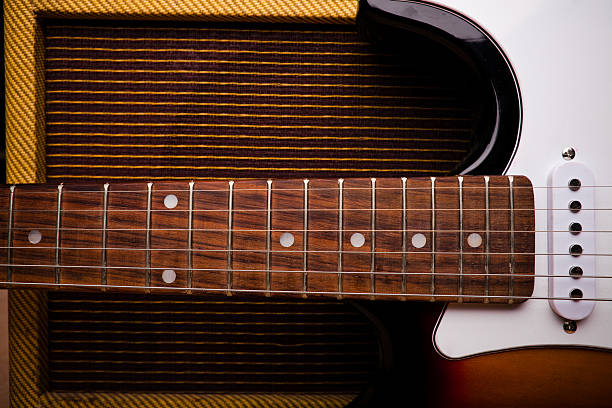 Still life of a mid-20th-century electric guitar leaning against a vintage amplifier