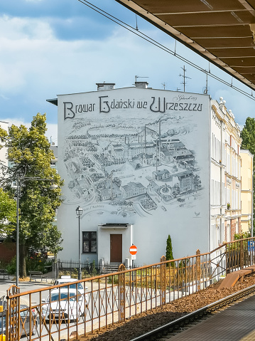 Gdansk, Poland - July 22 2023: Beautiful minimalist mural street art painted on wall of building with plan of Gdansk brewery seen from Wrzeszcz train platform