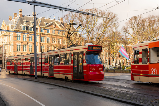 The Hague Netherlands - November 25, 2021: Side view of two red trams meeting on road bridge in the city of The Hague Netherlands November 25, 2021.