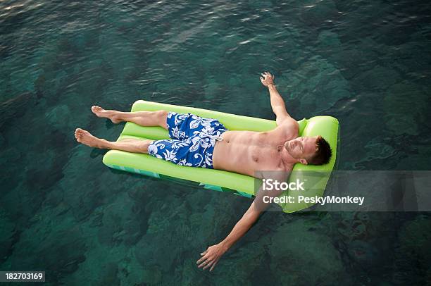 Ragazzo Galleggia Su Lilo In Verde Smeraldo E Acque - Fotografie stock e altre immagini di A petto nudo