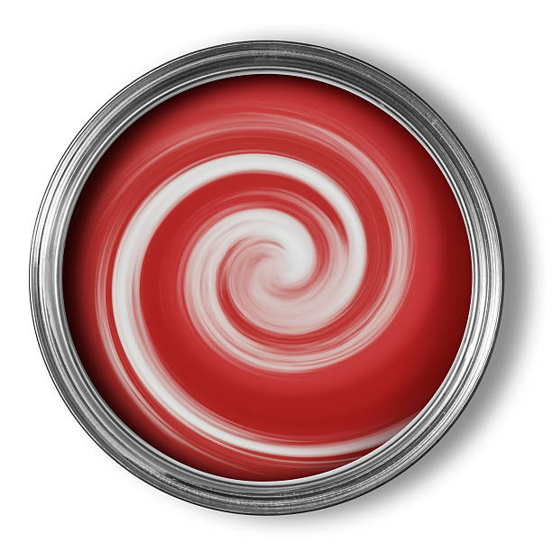 Tin of red paint being mixed with swirls on white stock photo