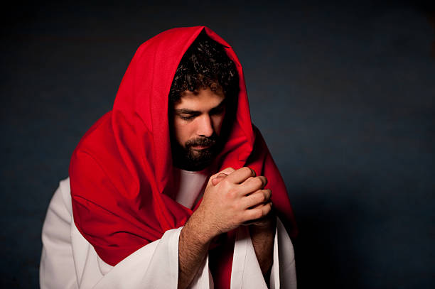 istock Jesus Christ praying in a dark room 182704216