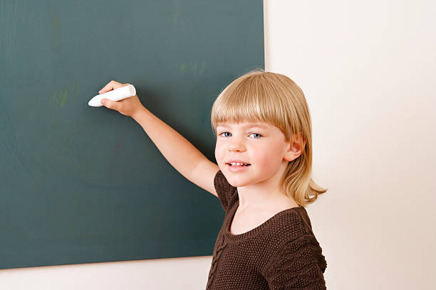 istock Young girl with chalk at the blackboard 182704274
