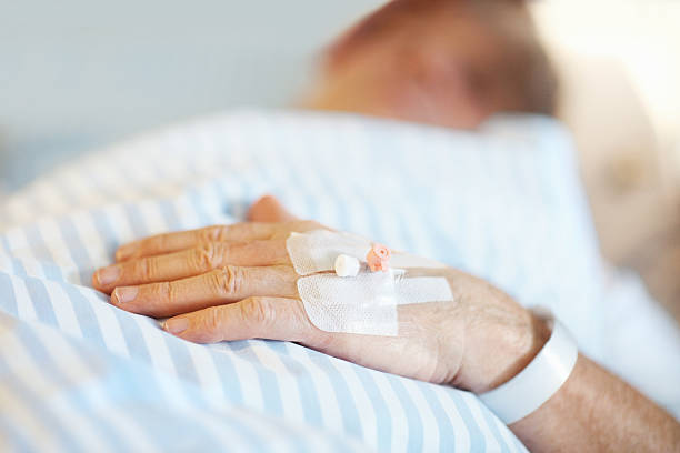 istock Patient lying on bed with IV drip inserted in hand 182704916