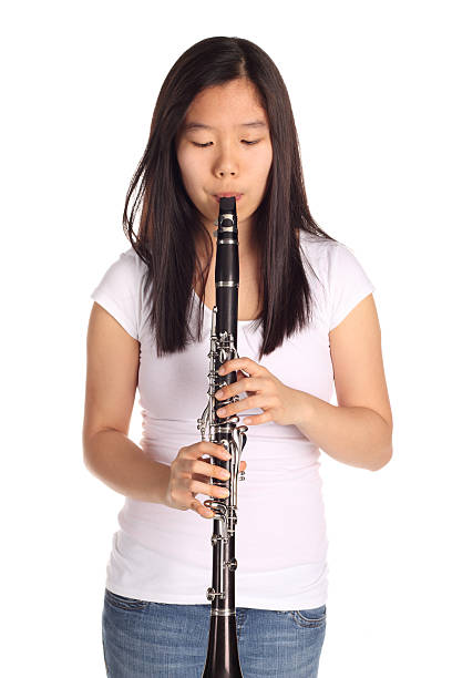 Young woman playing clarinet outdoors