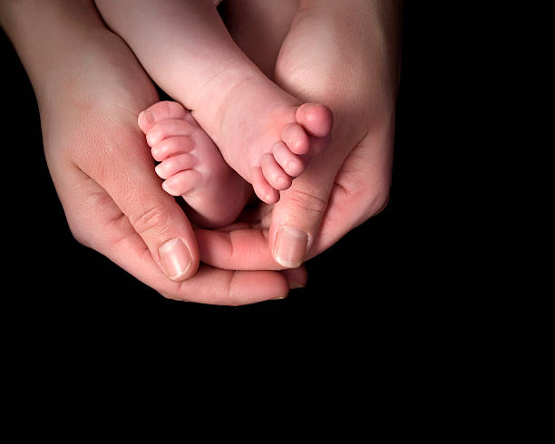 istock baby feet in hands 182705106