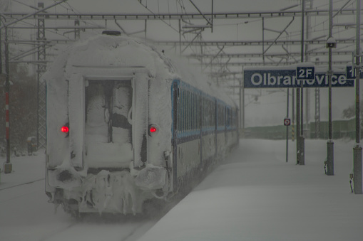 Electric trains near deep snowy platform and tunnel in Olbramovice CZ 12 02 2023