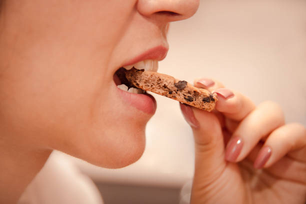 istock eating disorder due to problems and stress. woman eats up problems with sweets. 1827056334