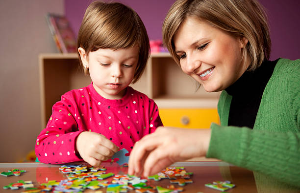istock Mother helping her daughter with puzzle 182707255