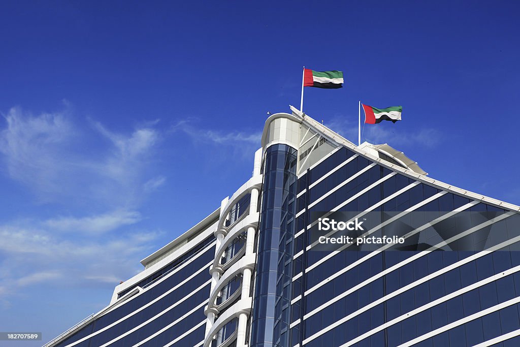 uae flags on building uae flags waving on top of a modern styled hotel in dubai - uae..other tower and construction in Dubai & UAE Images.. United Arab Emirates Flag Stock Photo