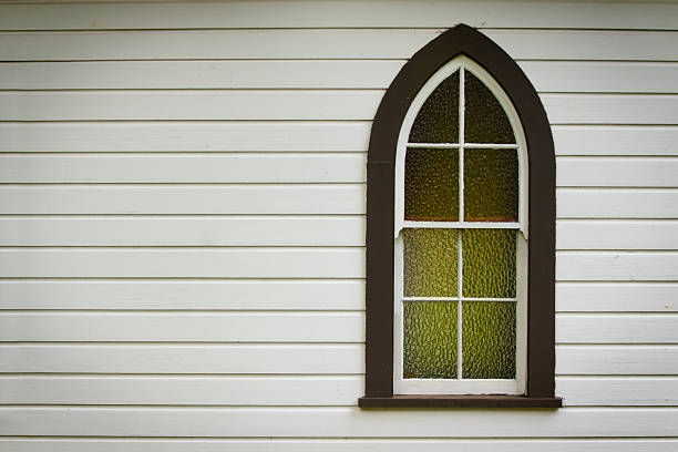 Closeup of church window with green light inside stock photo