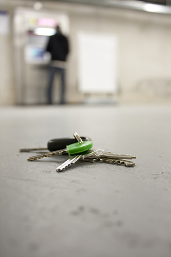 Keys and the person that lost them. Focus is on the keys.