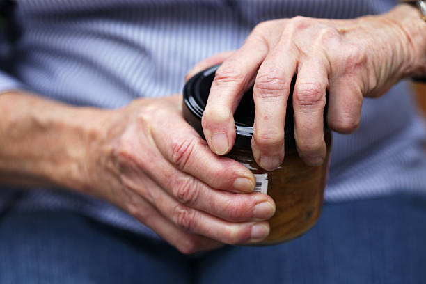 Senior opening jar Senior trying to open tough jar lid arthritis stock pictures, royalty-free photos & images