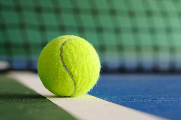 balle de tennis sur la ligne avec filet en arrière-plan - indoor tennis photos photos et images de collection