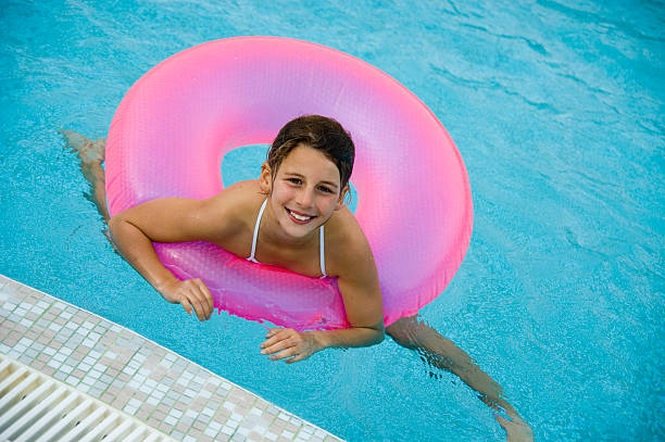 menina em rosa tubo de piscina flutuante - swimming tube inflatable circle imagens e fotografias de stock